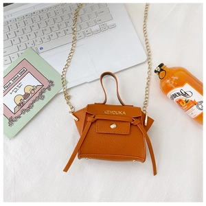 Dettaglio mini borsa arancione in pelle martellata con catena metallica e manico