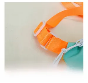 Détail de la boucle en plastique blanc et de la sangle en nylon orange du sac bandoulière