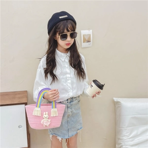 Pink woven straw handbag for children with rainbow handle and cute bunny ornament