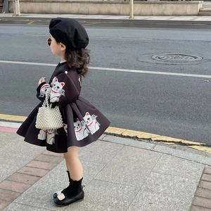 Girl's black dress with Maneki-neko print, pearl handbag and beret on a street setting