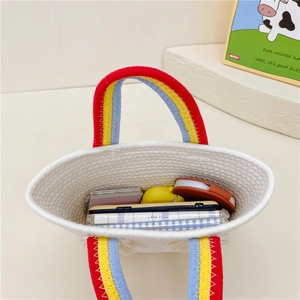 Handmade straw woven kids handbag with rainbow handles and spacious interior storage