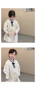 Close-up of girl wearing white handmade pearl woven crossbody bag with round handle