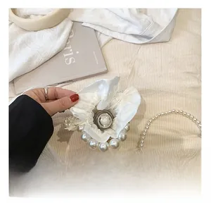 Internal capacity of girl's white pearl bucket bag showing storage space for items