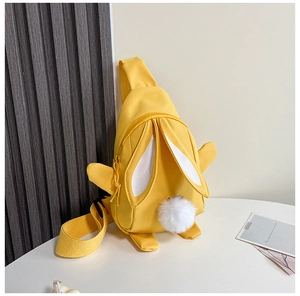 Detail der gelben Kinder-Brusttasche aus Nylon mit süßem 3D-Hasenohr und Bommel-Design