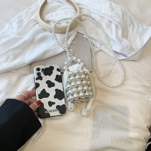 Detail of handmade pearl bucket bag with white drawstring inner pouch and long strap