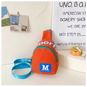 Detail der lebhaft orange-blauen Kinder-Brusttasche mit weißem Sports-Schriftzug und Gurt