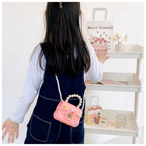 Pink quilted silicone crossbody bag for girls with pearl handle and cute charms detail