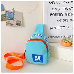 Detailaufnahme einer blauen Kinder-Brusttasche aus Nylon mit orangen Trägern und Aufdruck