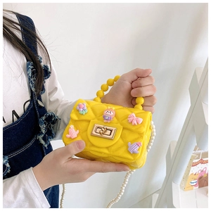 Dettaglio borsa bimba in silicone giallo con ciondoli cartoon e catena perle