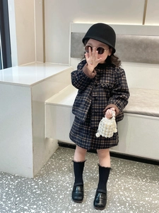 Detail of girl's vintage plaid blazer set featuring high-quality fabric and button closure