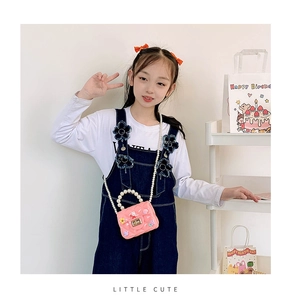 Detailed view of pink jelly bag featuring bunny charms and pearl handle strap