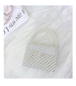 Close-up of handmade mini pearl woven handbag for girls with elegant beaded handle detail