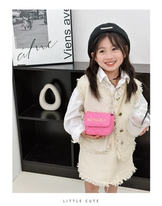 Fashionable girl wearing a pink quilted crossbody bag with gold chain and letter detail