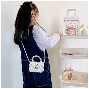 White quilted mini crossbody bag with pearl handle and cute colorful 3D resin charms