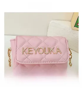 Detailed view of pink quilted PU leather crossbody bag with golden KEYOUKA metal logo