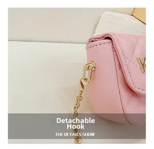 Detail of detachable golden metal hook on pink quilted PU leather crossbody bag