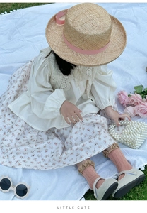 Tenue jupe à fleurs fille avec sac à perles et chapeau de paille sur l'herbe