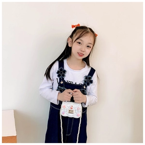 Dettaglio mini borsa trapuntata bianca per bambine con tracolla di perle e ciondoli fiori