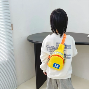 Sportliche gelbe Kindertasche mit blauem M-Logo und orangefarbenem Gurt am Modell