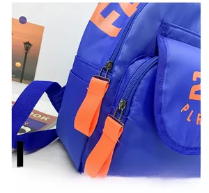 Macro detail of the smooth dual zippers with orange pull cords on the blue canvas backpack