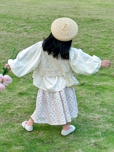 Vue de dos d'une fille avec jupe fleurie et mini sac à bandoulière en perles fait main