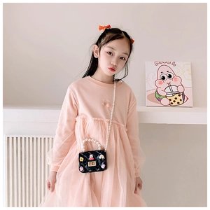 Detail of pink girls tulle dress with cherry embroidery and mini pearl handbag