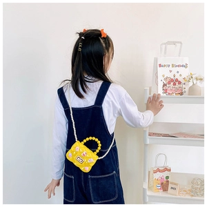 Dettaglio della mini borsa jelly gialla con tracolla di perle e decori a coniglietto