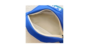Detail of blue kids waist bag showing nylon lining, white zipper and letter rubber patch