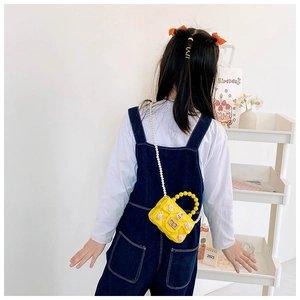 Borsa a tracolla gialla per bambina con catena di perle e fiori 3D indossata da modella