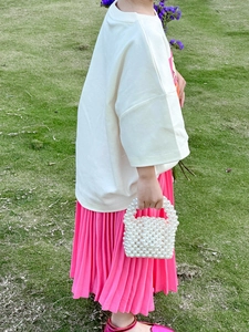 Détail d'un mini sac à main en perles fait main pour filles sur un fond de pelouse