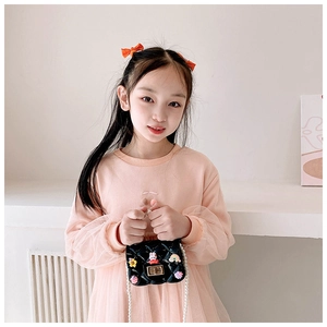 Close-up of girls' black mini jelly bag with pearl handle and cartoon charms on strap
