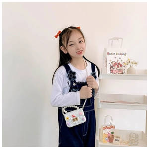 Detailed view of white quilted mini bag with pearl strap and cute bunny charms for girls