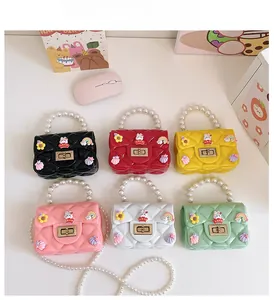 Flat lay of mini silicone jelly bags in six colors with pearl handles and charms