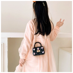 Mini borsa nera trapuntata per bambina con catena di perle e ciondoli a fumetto