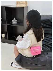Detail of pink quilted leather mini crossbody bag with gold metal logo and chain strap