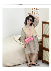 Détail d'un sac cylindrique rose pour fille avec quincaillerie dorée et sangle ajustable