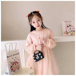 Close-up of pink knit dress with cherry detail and black pearl strap bag