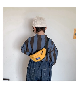 Rear view of a child wearing a yellow sports waist bag with letter logo on a white background