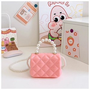 Detail of pink silicone jelly bag featuring quilted texture and elegant pearl handle strap