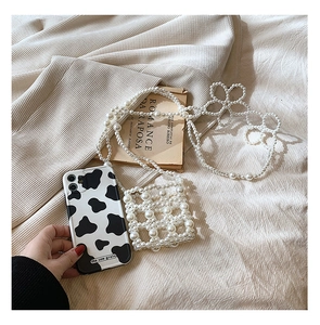 Detail shot of a small girl's pearl woven crossbody bag with stylish cow grain pattern