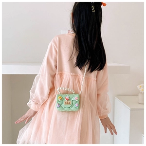 Girl wearing a mint green quilted jelly bag with pearls and cute bunny decorations