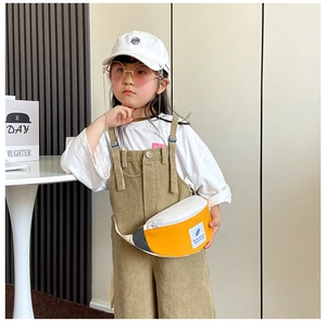 Sac de poitrine enfant bicolore avec fermeture éclair et patch porté en tenue décontractée