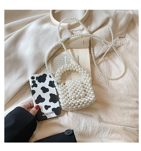 Mini sac à main perlé à côté d'un smartphone pour montrer sa petite taille ultra portable