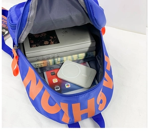 Internal compartment of the blue canvas backpack showing spacious storage for books and tablet