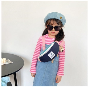 Détail du sac de poitrine pour enfants avec design bicolore et pendentif ours mignon