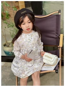 Detailed view of children's white quilted mini chain bag worn by a girl in floral dress