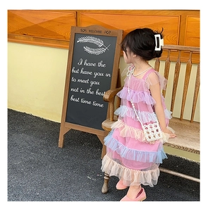 Detail of multi-layer mesh ruffle dress for girls in pastel pink and blue tones