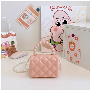 Close-up of pink jelly crossbody bag with quilted texture and pearl chain strap