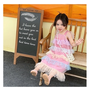 Little girl wearing a multi-color tiered mesh dress with a pearl woven crossbody bag