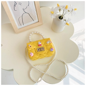 Detail of yellow silicone jelly bag for girls featuring pearl handle and cute 3D charms